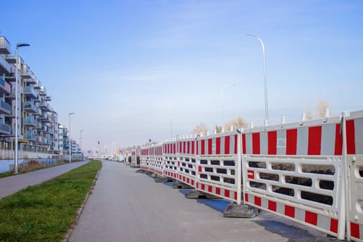 The roads of the city under construction are surrounded by barrier fences with red stripes. High quality photo