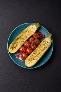Delicious zucchini cut into two halves baked with salt, spices and herbs on a dark concrete background