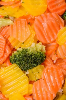 Delicious fresh vegetables steamed carrots, broccoli, cauliflower on a black plate on a dark concrete background