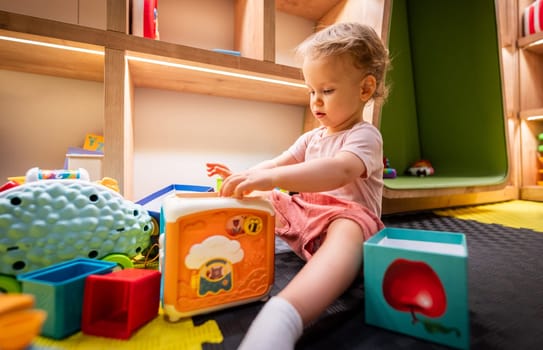 Toddler exploring colorful blocks and toys in a creative indoor playroom
