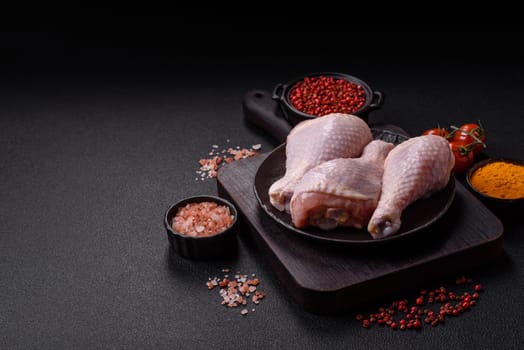 Raw chicken legs with salt, spices and herbs prepared for grilling