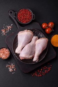 Raw chicken legs with salt, spices and herbs prepared for grilling