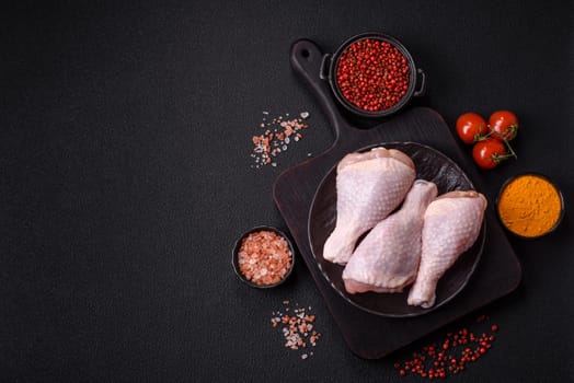 Raw chicken legs with salt, spices and herbs prepared for grilling