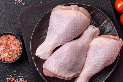 Raw chicken legs with salt, spices and herbs prepared for grilling