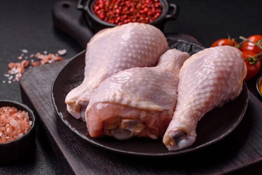 Raw chicken legs with salt, spices and herbs prepared for grilling