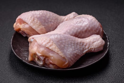 Raw chicken legs with salt, spices and herbs prepared for grilling