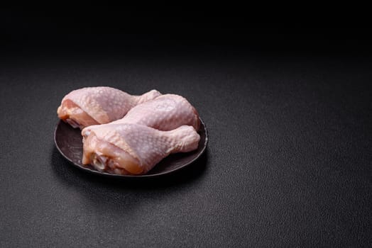Raw chicken legs with salt, spices and herbs prepared for grilling