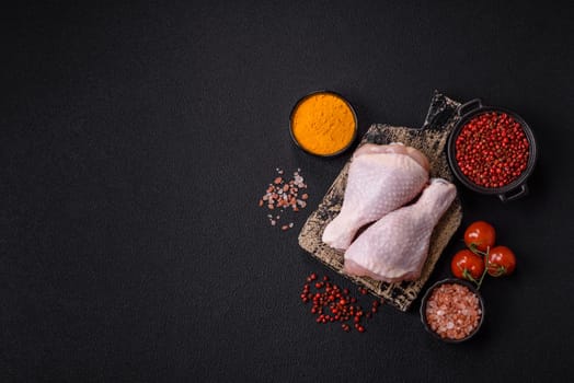 Raw chicken legs with salt, spices and herbs prepared for grilling