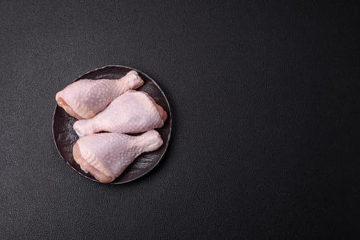 Raw chicken legs with salt, spices and herbs prepared for grilling