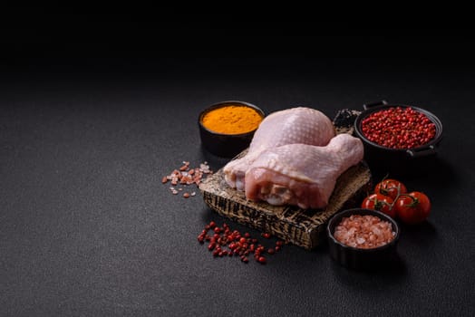 Raw chicken legs with salt, spices and herbs prepared for grilling