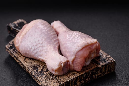 Raw chicken legs with salt, spices and herbs prepared for grilling
