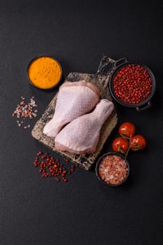 Raw chicken legs with salt, spices and herbs prepared for grilling
