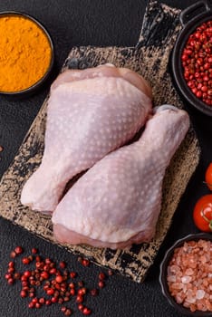 Raw chicken legs with salt, spices and herbs prepared for grilling