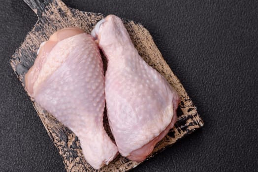 Raw chicken legs with salt, spices and herbs prepared for grilling