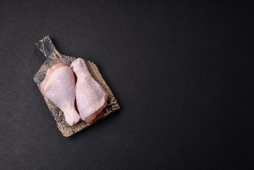 Raw chicken legs with salt, spices and herbs prepared for grilling