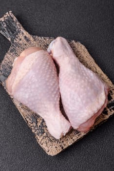 Raw chicken legs with salt, spices and herbs prepared for grilling