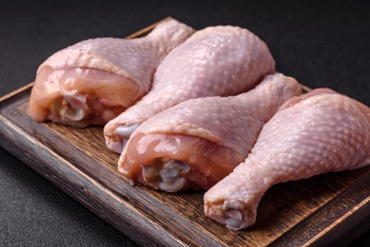 Raw chicken legs with salt, spices and herbs prepared for grilling