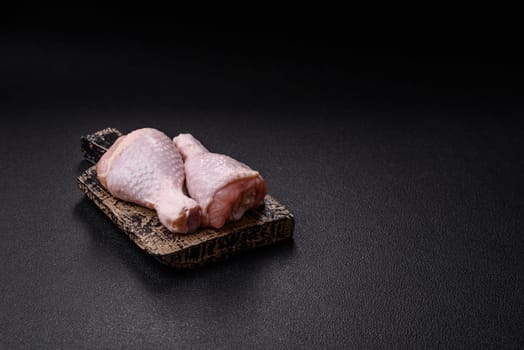 Raw chicken legs with salt, spices and herbs prepared for grilling