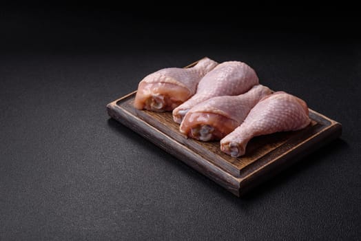 Raw chicken legs with salt, spices and herbs prepared for grilling