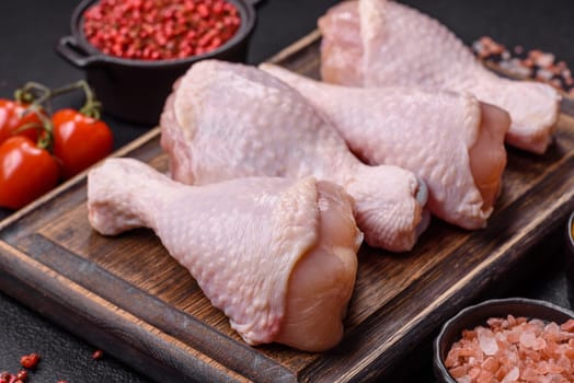Raw chicken legs with salt, spices and herbs prepared for grilling