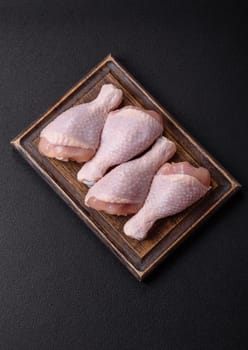 Raw chicken legs with salt, spices and herbs prepared for grilling