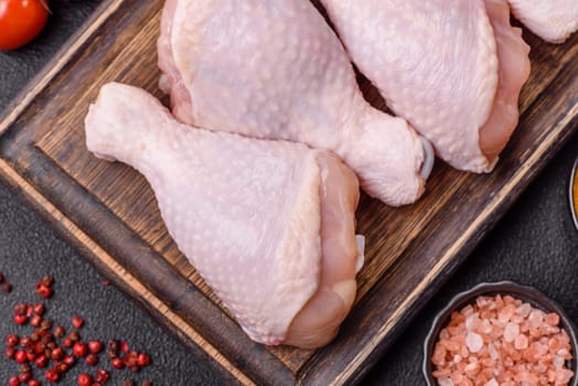 Raw chicken legs with salt, spices and herbs prepared for grilling