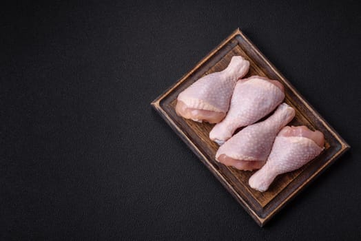 Raw chicken legs with salt, spices and herbs prepared for grilling