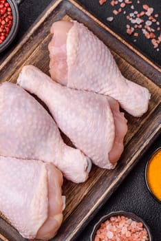 Raw chicken legs with salt, spices and herbs prepared for grilling
