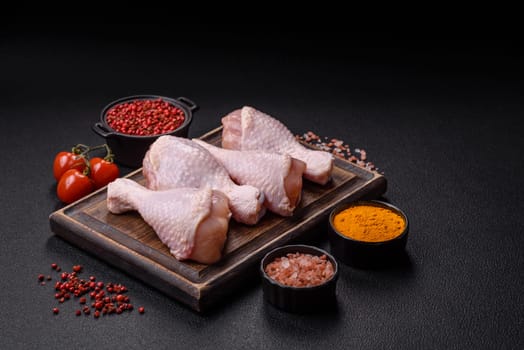 Raw chicken legs with salt, spices and herbs prepared for grilling
