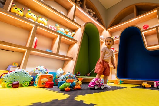 Curious child playing with toys in a vibrant and interactive play space designed for creativity, learning, and fun activities