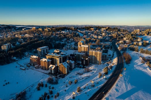 New buildings for sale apartments on Zlatibor town and low cloud over Zlatibor Mountain at winter sunset, Cajetina, Serbia.