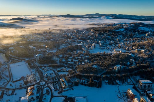 Panoramic aerial view of Zlatibor town and low cloud over Zlatibor Mountain at winter sunset, Cajetina, Serbia.