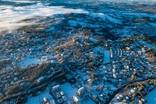 Panoramic aerial view of Zlatibor town and low cloud over Zlatibor Mountain at winter sunset, Cajetina, Serbia.