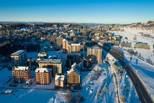 Panoramic aerial view of new buildings for sale on Zlatibor town and clear sky over Zlatibor Mountain at winter sunset, Cajetina, Serbia.