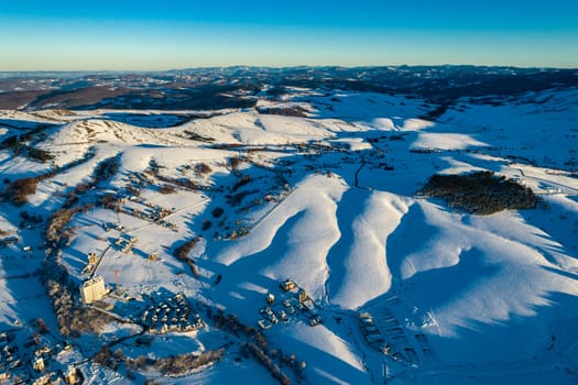 Panoramic aerial view of Zlatibor town and low cloud over Zlatibor Mountain at winter sunset, Cajetina, Serbia.