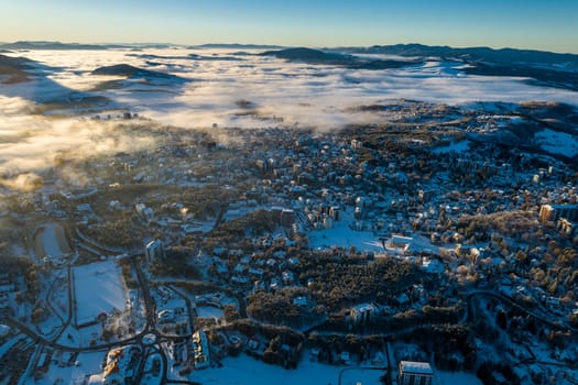 Panoramic aerial view of Zlatibor town and low cloud over Zlatibor Mountain at winter sunset, Cajetina, Serbia.