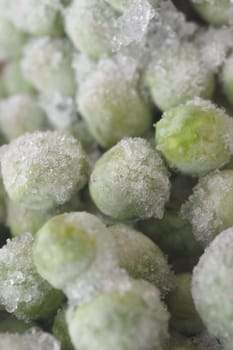 A detailed, closeup view of frozen green peas that are placed in a clear plastic bag