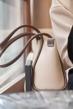 An elegant handbag is placed on a table, showcasing a contemporary design that blends well