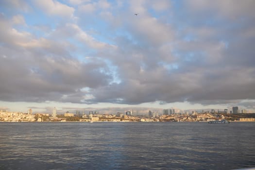 A stunning view of a city skyline reflecting over calm waters with dramatic clouds.
