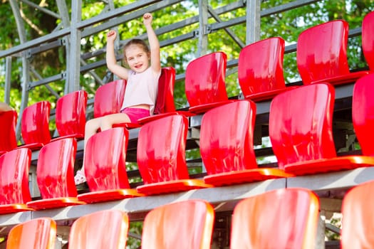 girl in the stands cheering for athletes, spring season