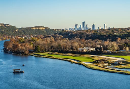 Golf course lines the Colorado river with downtown Austin Texas in distance from Pennybacker bridge overlook