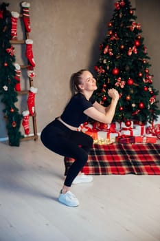 Athletic woman doing exercises in room with Christmas