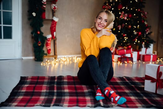 blonde woman sitting in room with Christmas tree Christmas