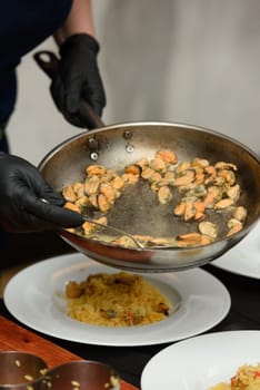 preparation of paella with chicken and mussels.