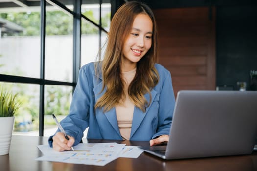 Asian woman working with laptop computer she analyst financial advisor preparing statistic report studying documents, Businesswoman audit financial charts and graphs