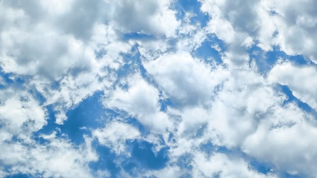 Background of white fluffy clouds on the background blue sky.