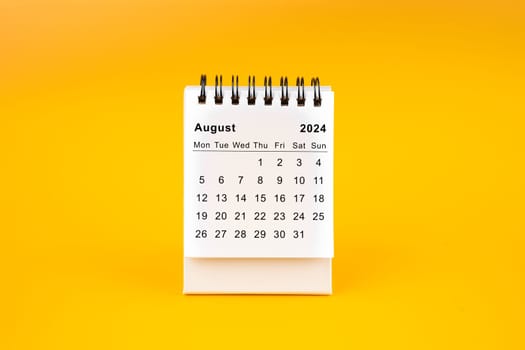 White clean August desk calendar for 2024 year on yellow background.