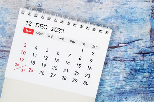 December 2023 Monthly desk calendar for 2023 year on old blue wooden background.