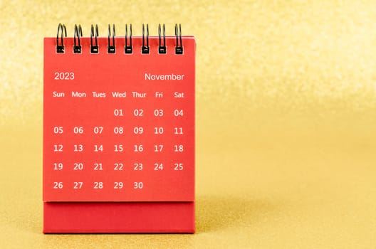 Red November 2023 Monthly desk calendar for 2023 year on golden color background.