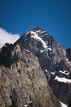 Caucasus mountains. Stone slopes of mountains with pieces of snow on a sunny day, close-up.